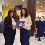 Dos jóvenes sosteniendo una carpeta en un pleno municipal