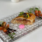 Tapa gourmet presentada en un plato elegante con guarnición