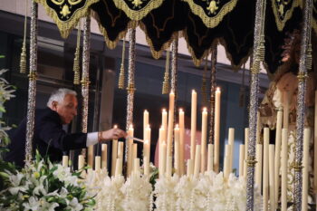 Hombre encendiendo velas en el trono de la Virgen de los Dolores