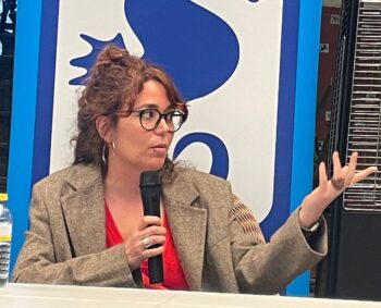 Ilu Ros hablando en un evento cultural sobre su obra y experiencias.