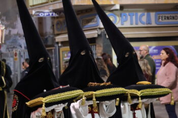 Tres personas con capirotes en la procesión del Santo Entierro en San Pedro del Pinatar