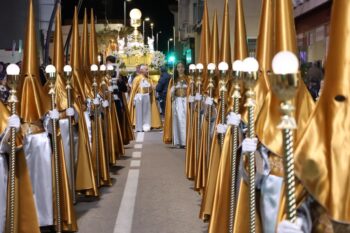 Procesión del Santo Entierro en San Pedro del Pinatar con participantes en túnicas doradas.