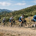 Grupo de ciclistas en una ruta montañosa durante un evento solidario