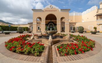 Entrada del Grand Hyatt La Manga Club Golf & Spa con flores rojas