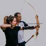 Instructor y estudiante practicando tiro con arco en San Javier