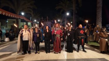 Grupo de personas con antorchas en un evento histórico en Los Alcázares