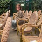 Ilu Ros sentada entre sillas de mimbre en un ambiente acogedor