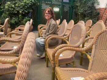 Ilu Ros sentada entre sillas de mimbre en un ambiente acogedor