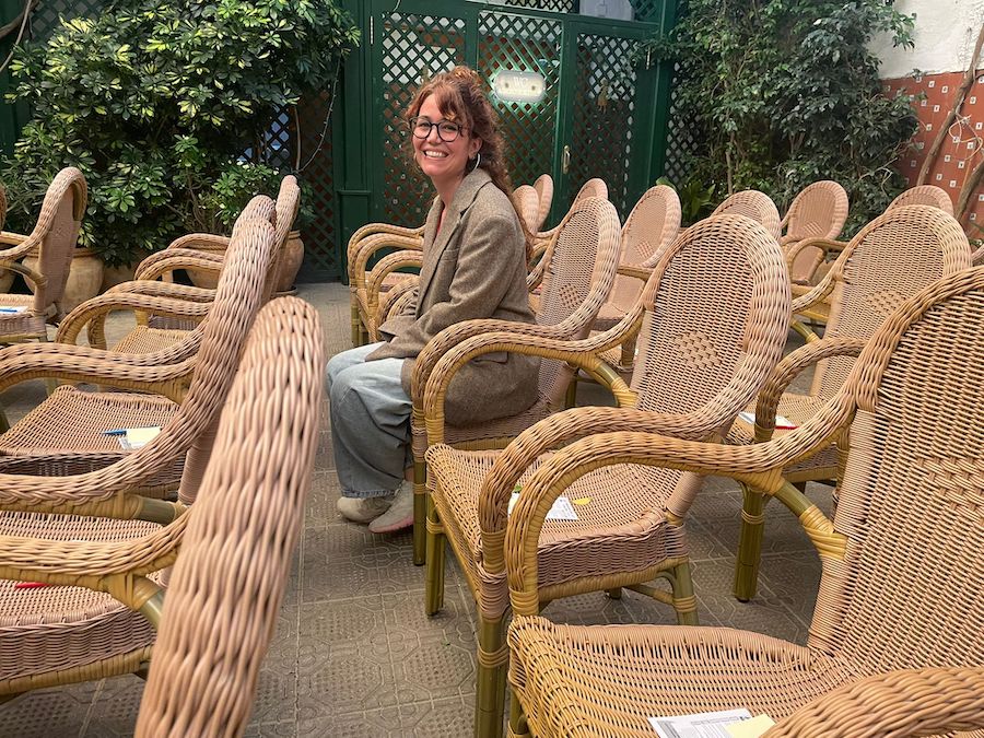 Ilu Ros sentada entre sillas de mimbre en un ambiente acogedor