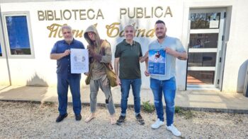 Cuatro personas sosteniendo carteles frente a la Biblioteca Miguel Galindo