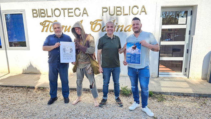 Cuatro personas sosteniendo carteles frente a la Biblioteca Miguel Galindo