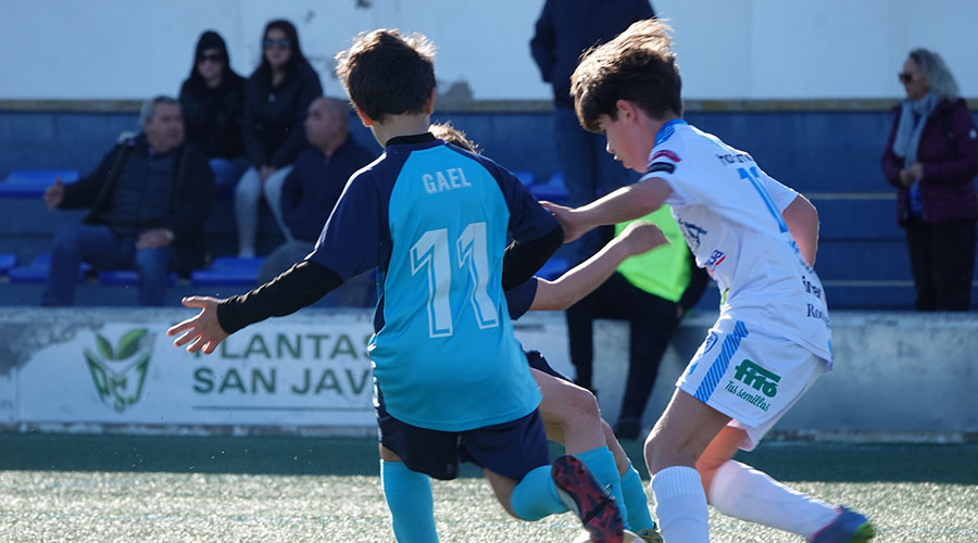 Dos jóvenes futbolistas compiten en un partido de fútbol base en San Javier