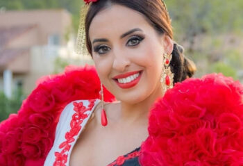 Maribel Castillo sonriente con vestimenta flamenca en un evento cultural