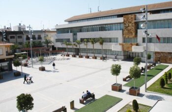 Vista de la Plaza de España en San Javier con personas y árboles.