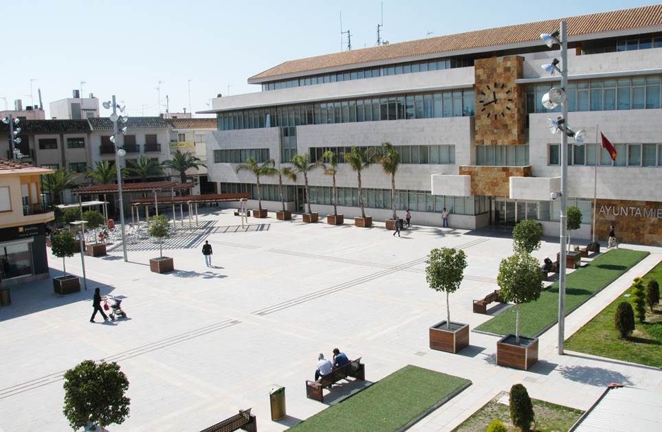 Vista de la Plaza de España en San Javier con personas y árboles.