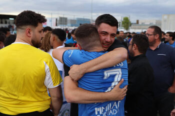 Jugadores del San Javier CF celebran su ascenso a la Tercera Federación con abrazos y alegría.