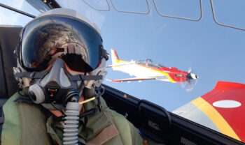 Piloto en cabina con avión acrobático en el fondo