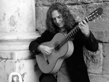 Guitarrista Tomatito tocando la guitarra en un festival de flamenco.