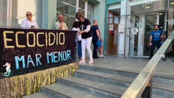 Manifestantes sosteniendo una pancarta sobre el ecocidio del Mar Menor en Cartagena