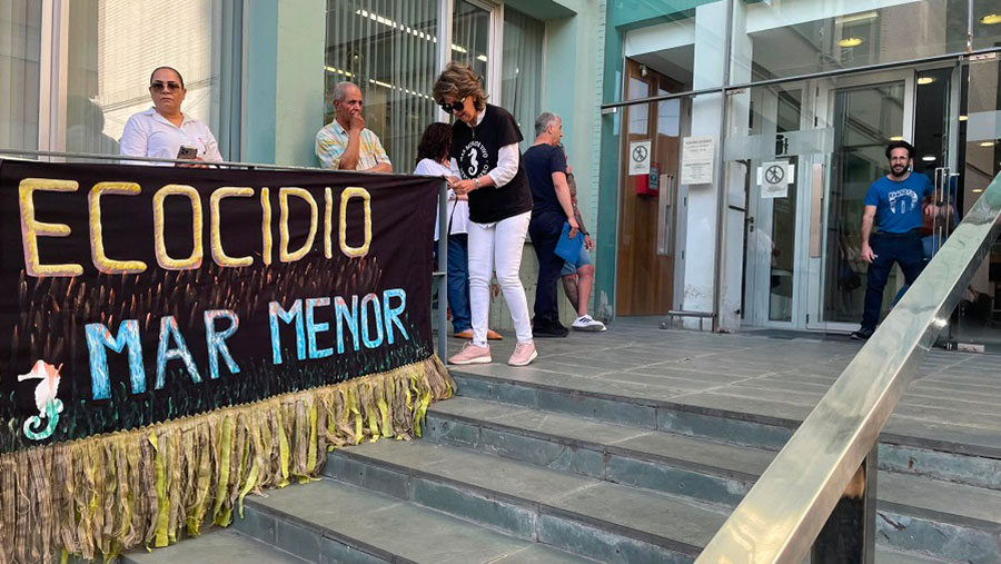 Manifestantes sosteniendo una pancarta sobre el ecocidio del Mar Menor en Cartagena