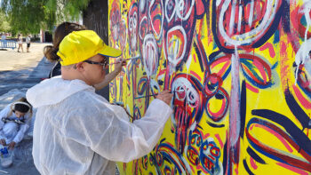 Artistas pintando un mural colorido en el Festival Internacional de Arte Urbano.