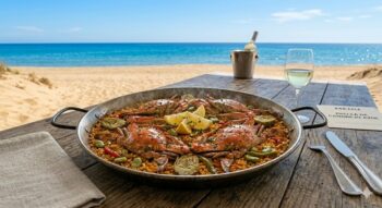 Plato de paella con cangrejo azul en la playa