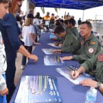 Miembros de la Patrulla Águila firmando autógrafos en un evento aéreo