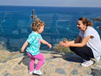 Mujer y niña jugando frente al mar en un día soleado