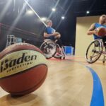 Jugadores de baloncesto en silla de ruedas entrenando en un gimnasio