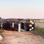 Coche de policía volcado en un campo junto a la carretera