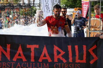 Corredor en la carrera de obstáculos Pinatarius con espuma y pancarta