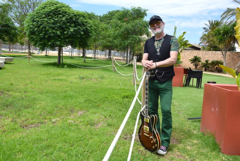 Antonio Baeza posando con guitarra en un parque verde