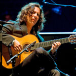 Músico tocando la guitarra en un festival flamenco