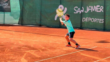 Niño jugando al tenis en la pista del Open San Javier