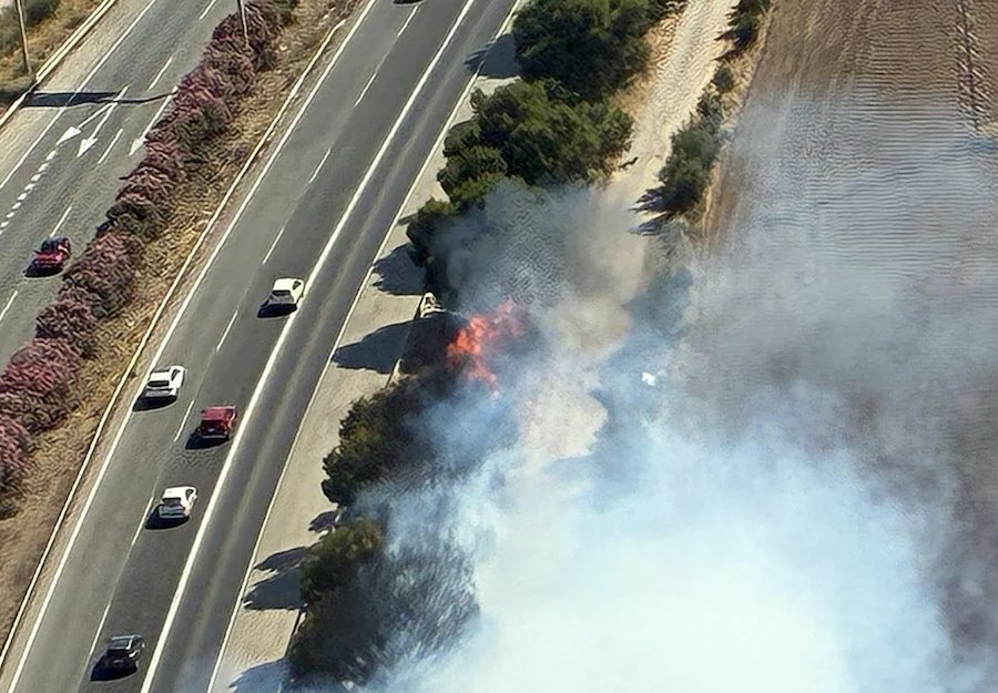Incendio en el arcén de la autopista AP-7 con humo visible.