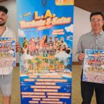 Dos hombres sosteniendo un cartel del festival de bachata y salsa