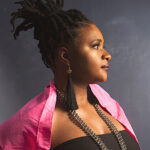 Lizz Wright en perfil, con cabello recogido y atuendo colorido