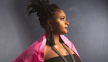 Lizz Wright en perfil, con cabello recogido y atuendo colorido