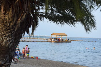 Vista del balneario de Los Viudes en Santiago de la Ribera con familias en la playa.