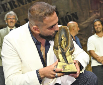 Rafa del Calli besando el trofeo Lámpara Minera en el festival flamenco.