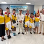 Grupo de jóvenes deportistas con medallas en recepción oficial