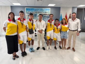 Grupo de jóvenes deportistas con medallas en recepción oficial