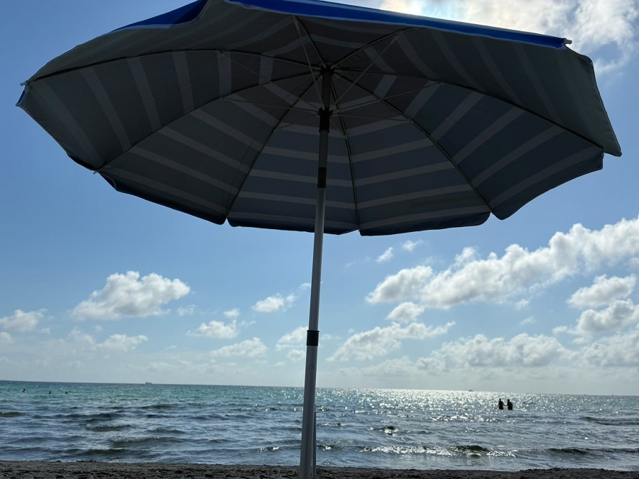 Sombrilla de playa con vista al mar y nubes